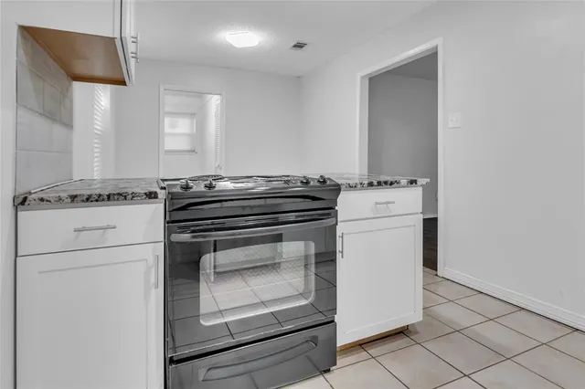a stove top oven sitting inside of a kitchen