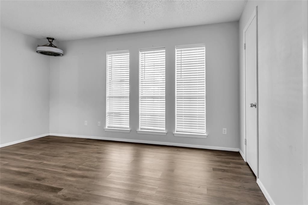 805 Irwin Drive, Unit B Hurst, TX 76053 - Photo 14 of 26 an empty room with wooden floor and a window