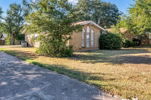 a view of a house with a yard and large trees