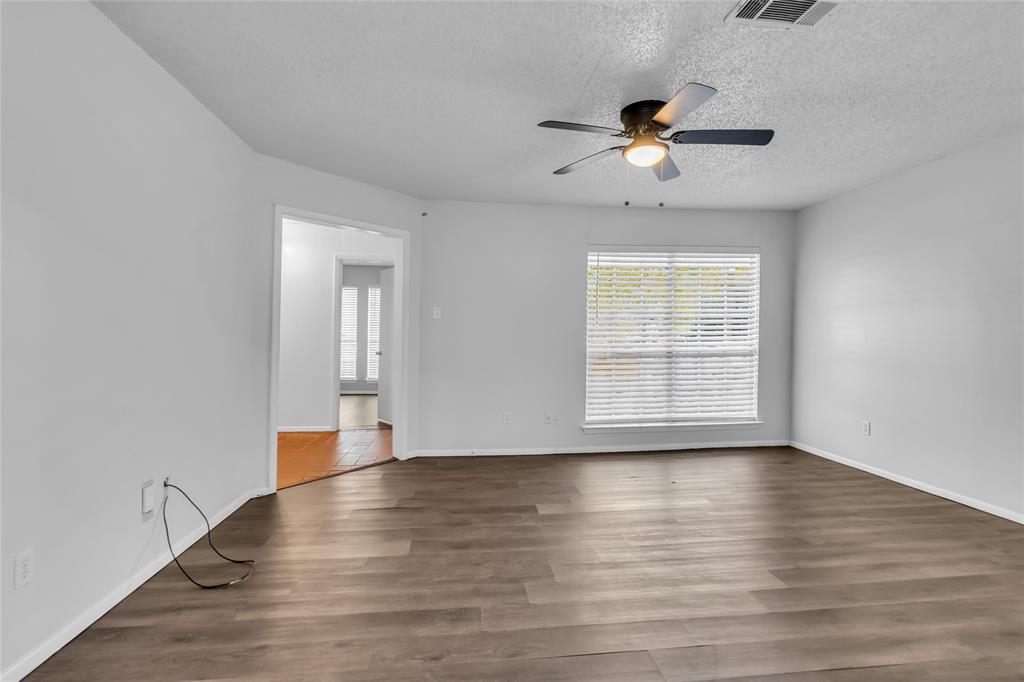805 Irwin Drive, Unit B Hurst, TX 76053 - Photo 7 of 26 a view of an empty room with wooden floor and a window