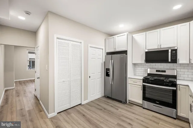 a kitchen with stainless steel appliances a refrigerator and a stove top oven