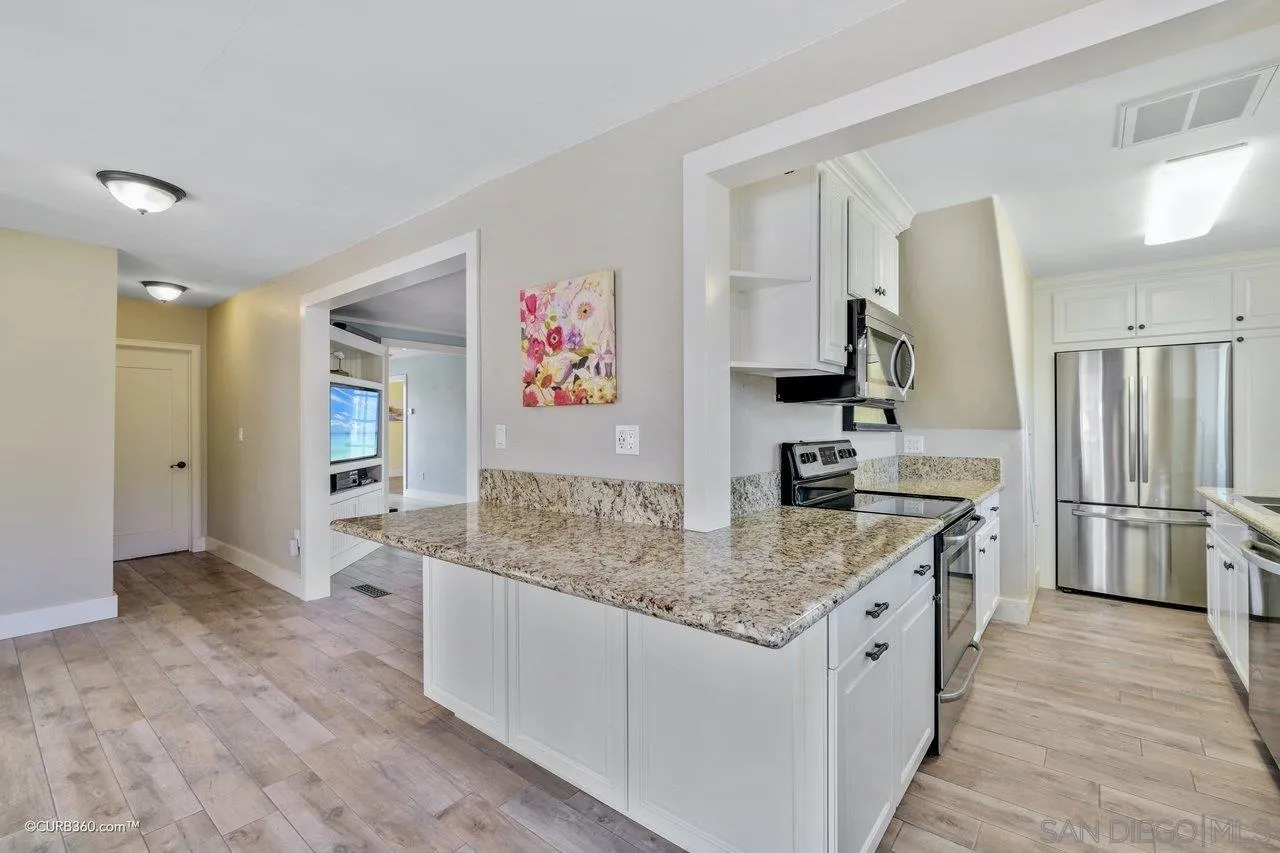 1544 Grove Road El Cajon, CA 92020 - Photo 23 of 42 a kitchen with stainless steel appliances granite countertop a sink stove and refrigerator
