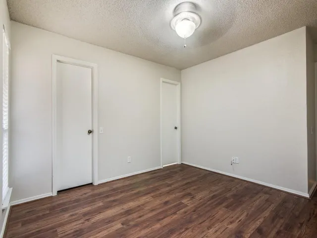 a view of a room with wooden floor and white walls