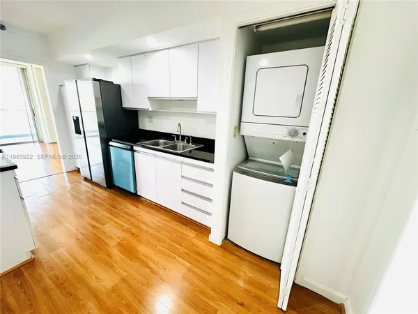 a kitchen with a refrigerator sink and cabinets