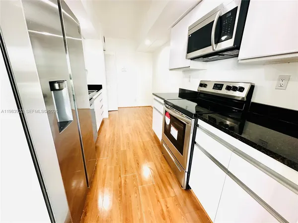 a kitchen with stainless steel appliances a refrigerator microwave and sink