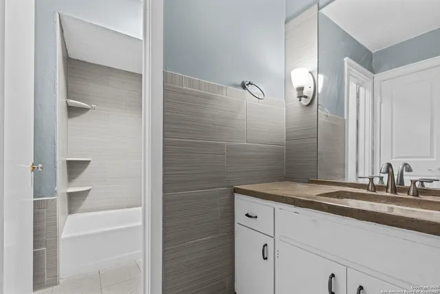 a bathroom with a granite countertop sink and a mirror