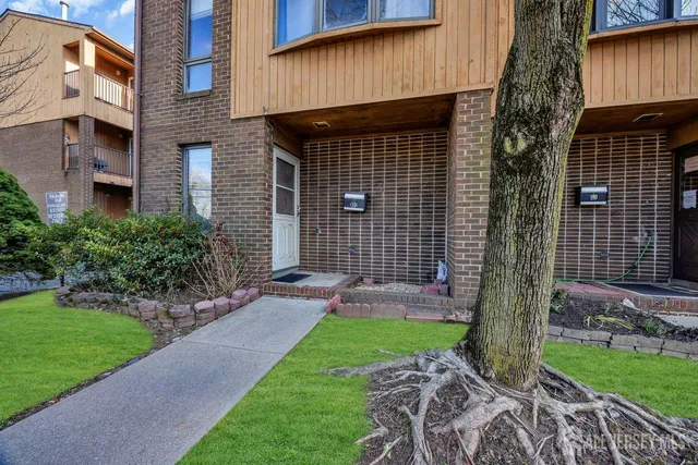 an empty room with wooden floor closet and windows