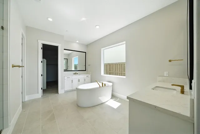 a spacious bathroom with a bathtub sink and a mirror