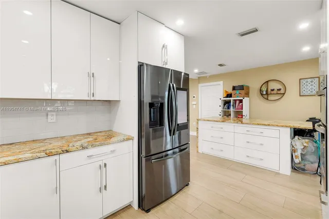 a kitchen with stainless steel appliances white cabinets and a refrigerator