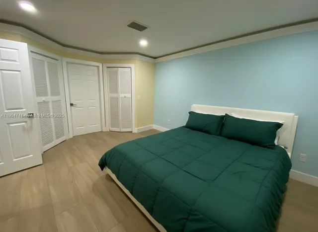 a bedroom with a bed and wooden floor