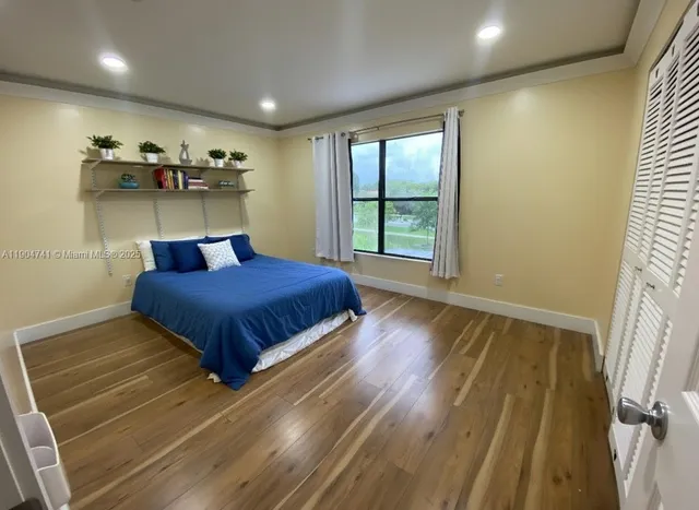 a bedroom with a bed and a wooden floor