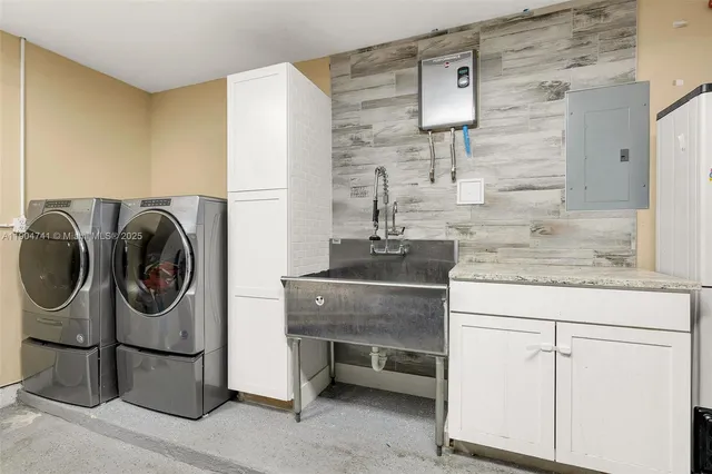 a utility room with cabinets dryer and washer