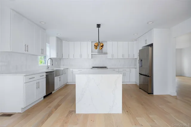 a kitchen with a refrigerator sink and cabinets