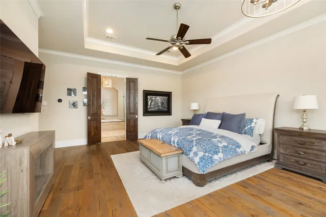 a spacious bedroom with a bed and a flat screen tv