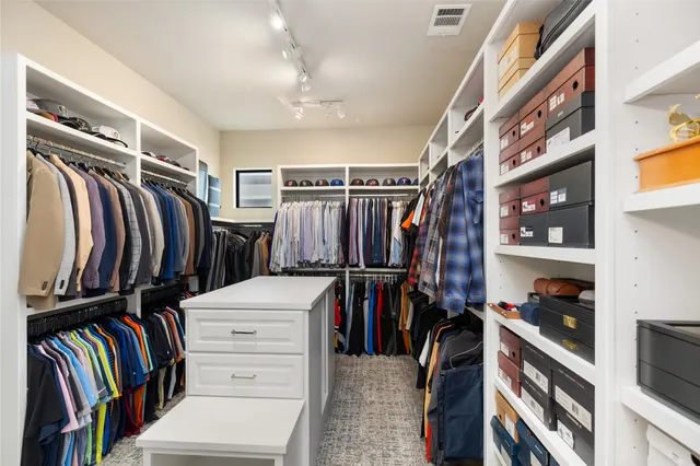 a view of walk in closet with clothes and shoes