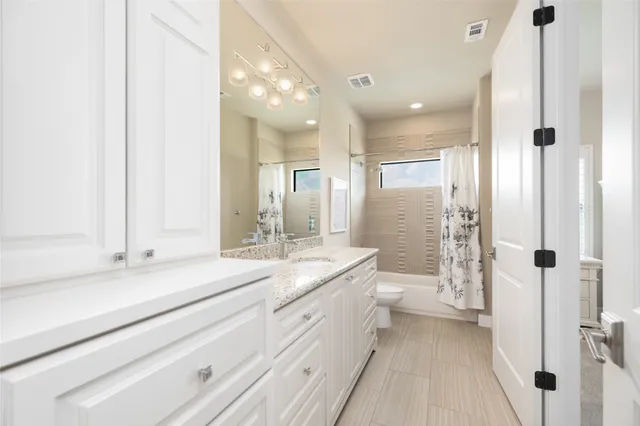 a bathroom with a granite countertop sink mirror and a toilet