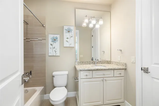 a bathroom with a granite countertop toilet sink and mirror