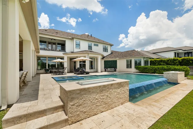 a view of house with swimming pool and sitting area