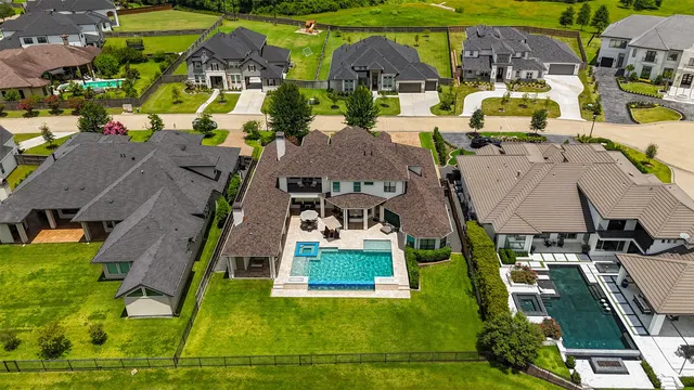 an aerial view of residential houses with outdoor space and parking