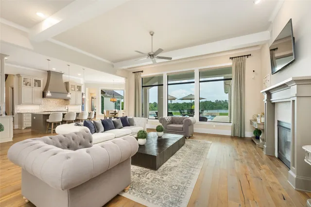 a living room with furniture fireplace and a large window
