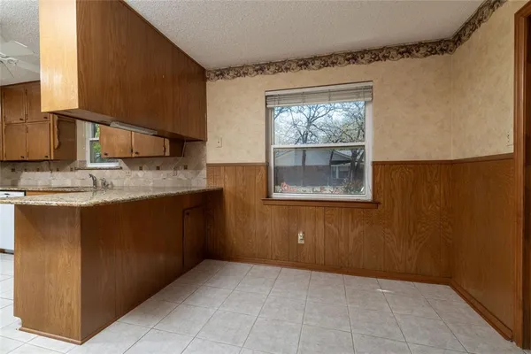 a kitchen with a sink window and cabinets