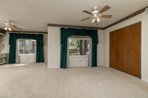 a living room with furniture and two large window