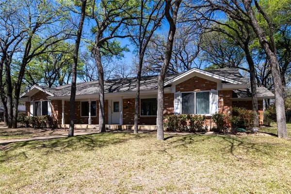a view of a house with a tree in front of it