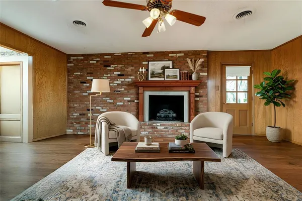 an empty room with wooden floor a fireplace and windows