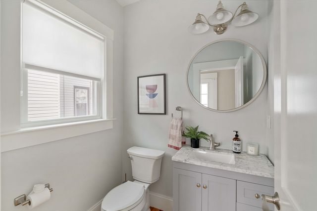 a bathroom with a granite countertop toilet a sink and mirror