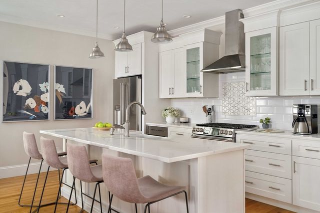a kitchen with stainless steel appliances kitchen island granite countertop a sink a stove and cabinets