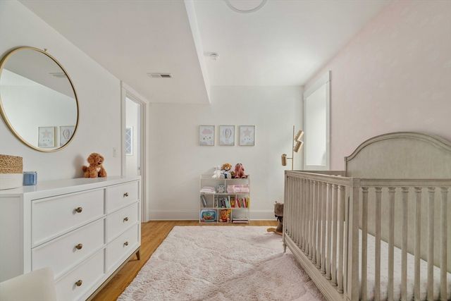 a view of a bedroom with baby crib and furniture