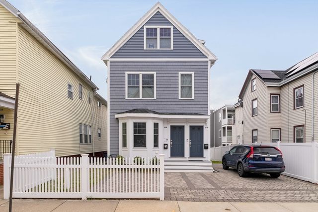 a car parked in front of a white house