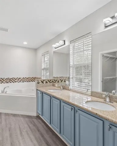 a bathroom with a granite countertop sink and a bathtub