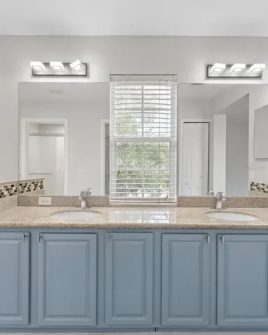 a bathroom with a granite countertop sink and a large mirror