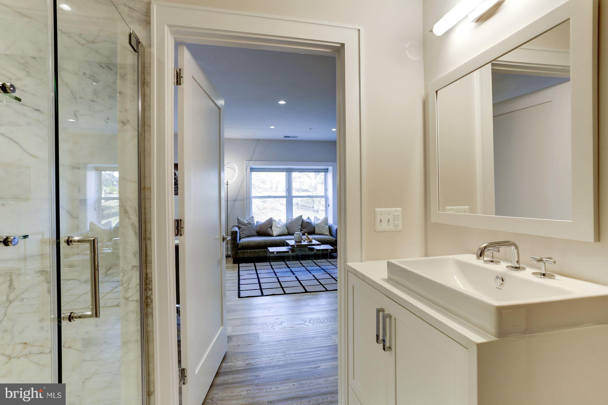 2434 16th Street Northwest, Unit 301 Washington, DC 20009 - Photo 26 of 30 a en suite bathroom with a sink a mirror and a shower