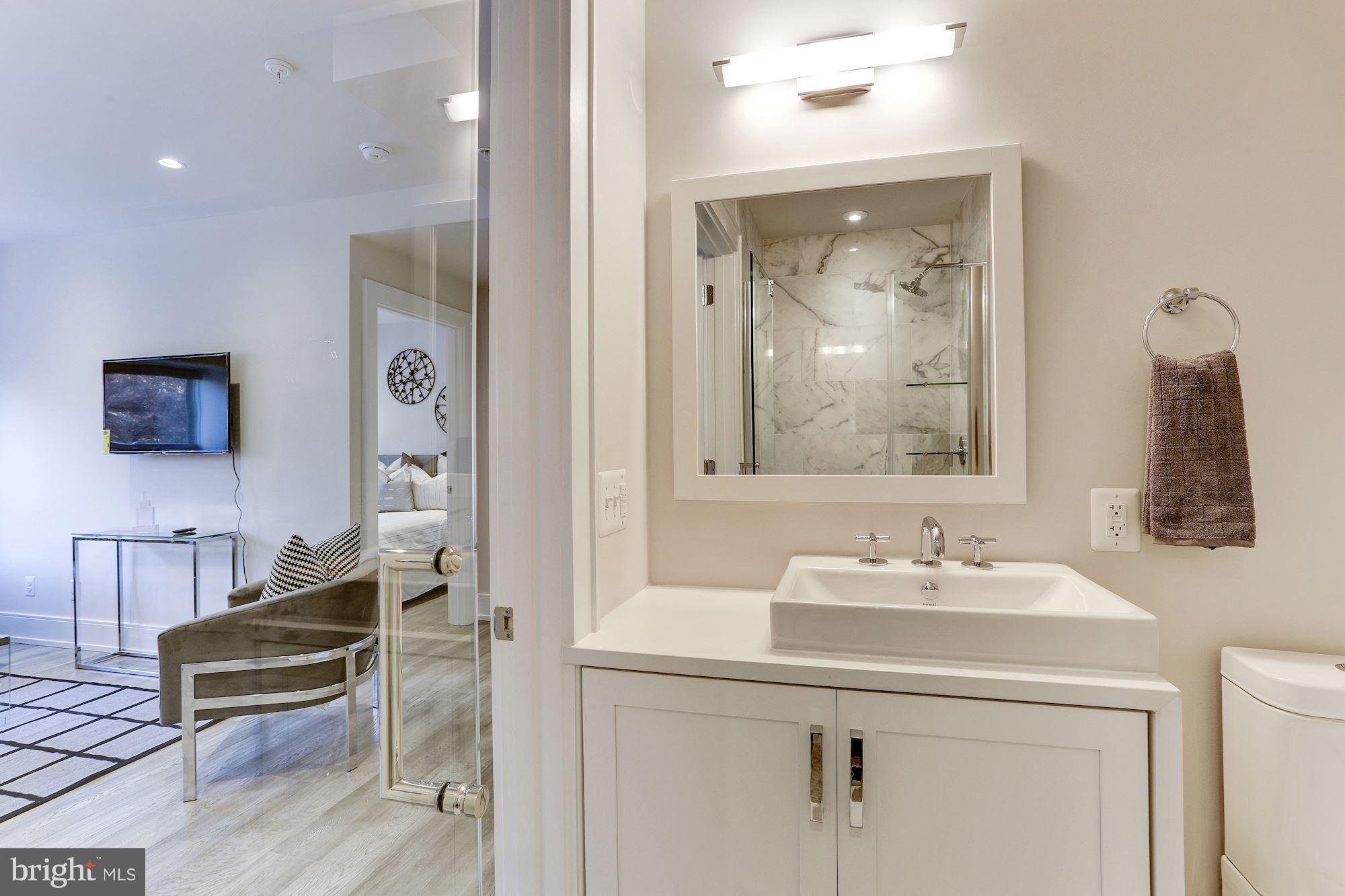 2434 16th Street Northwest, Unit 301 Washington, DC 20009 - Photo 27 of 30 a en suite bathroom with a sink mirror and vanity