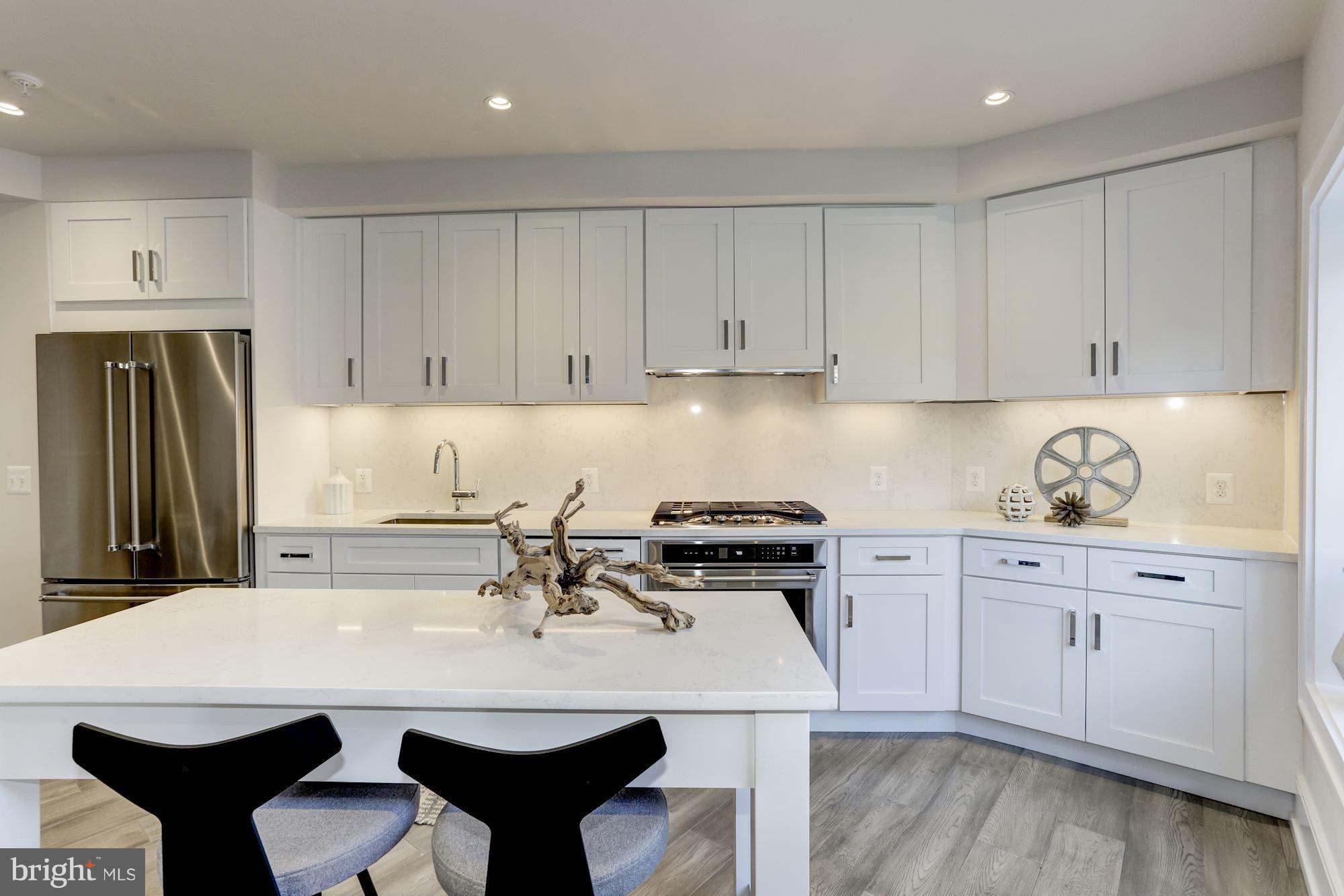 2434 16th Street Northwest, Unit 301 Washington, DC 20009 - Photo 7 of 30 a kitchen with a table chairs stove and refrigerator