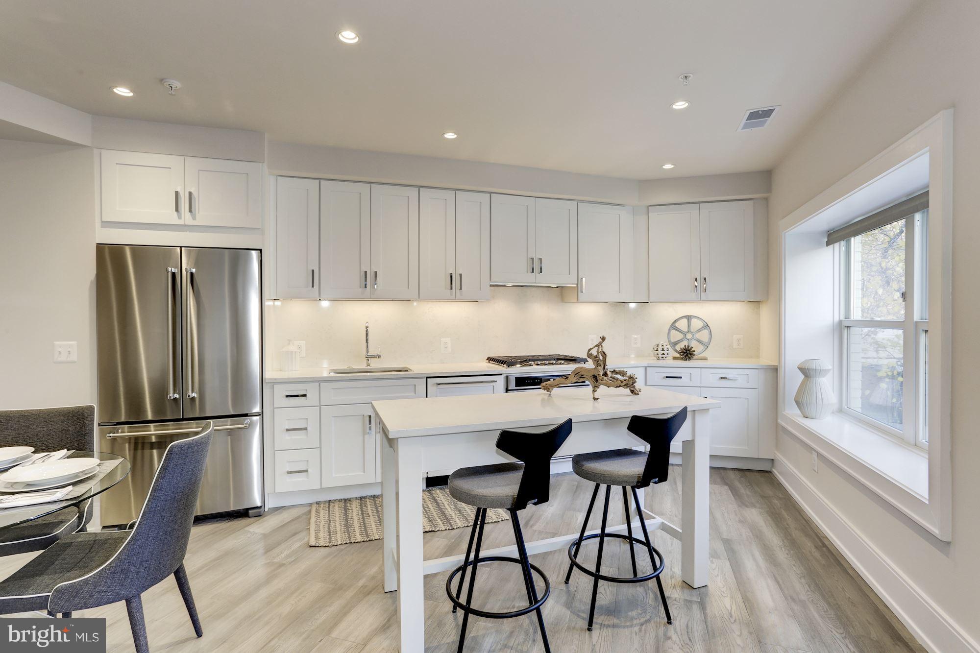 2434 16th Street Northwest, Unit 301 Washington, DC 20009 - Photo 8 of 30 a kitchen with stainless steel appliances granite countertop a refrigerator and a stove top oven