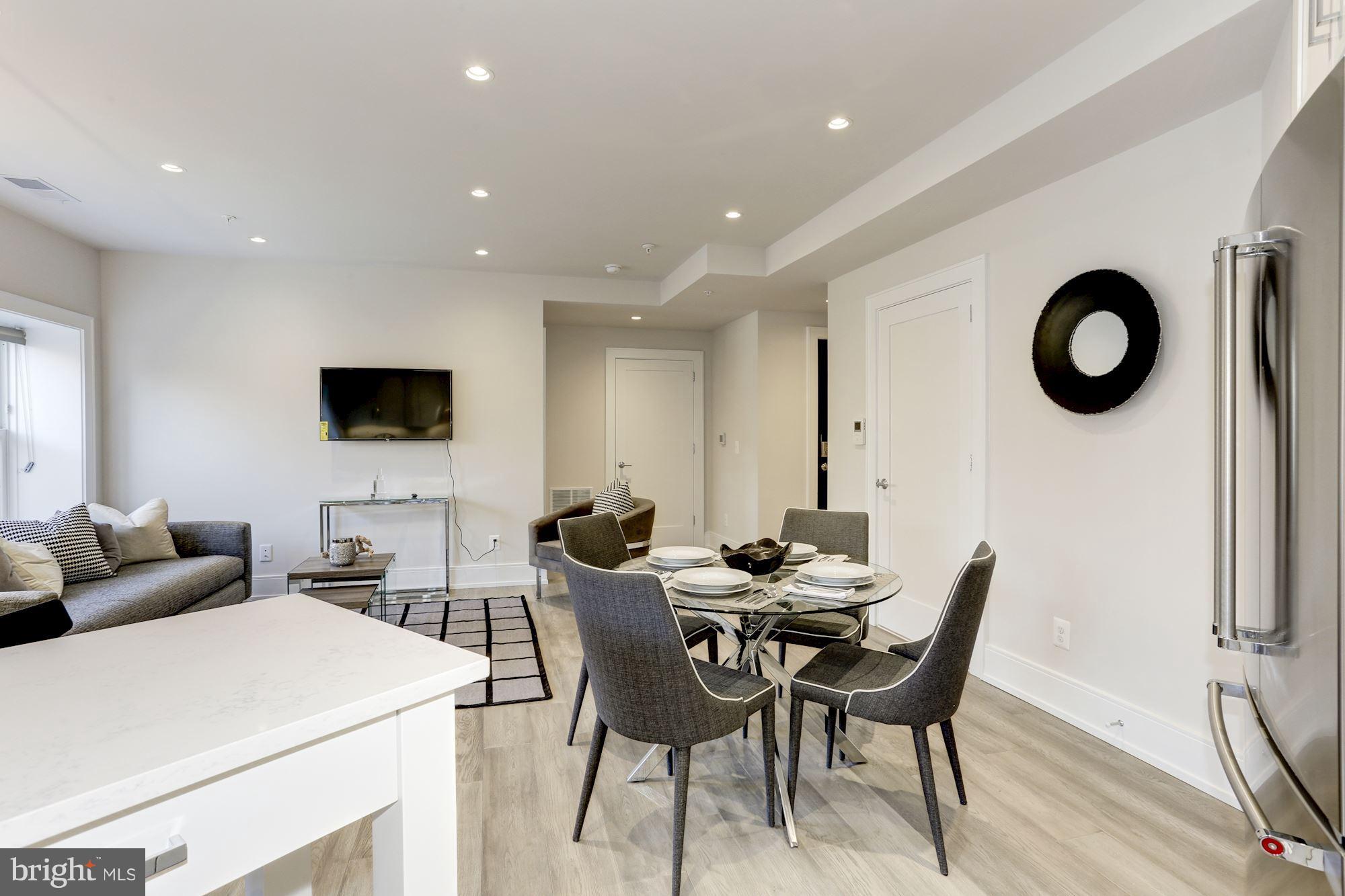 2434 16th Street Northwest, Unit 301 Washington, DC 20009 - Photo 9 of 30 a view of a dining room with furniture and a flat screen tv