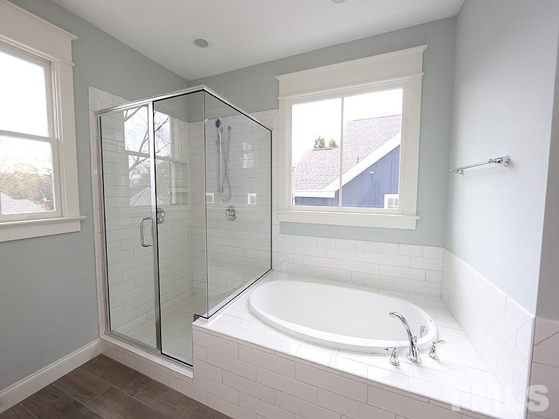 2004 Wiggs Street Raleigh, NC 27608 - Photo 17 of 25 a bathroom with a tub a window and a glass door shower