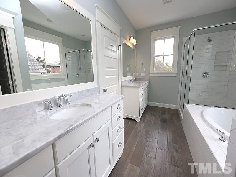 2004 Wiggs Street Raleigh, NC 27608 - Photo 18 of 25 a spacious bathroom with a granite countertop tub sink a mirror and a shower