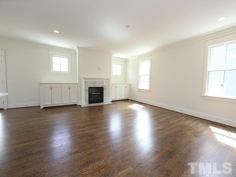 2004 Wiggs Street Raleigh, NC 27608 - Photo 6 of 25 an empty room with wooden floor fireplace and windows