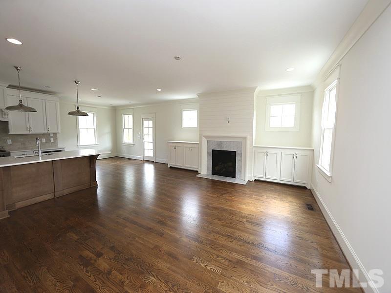 2004 Wiggs Street Raleigh, NC 27608 - Photo 7 of 25 an empty room with wooden floor and a kitchen