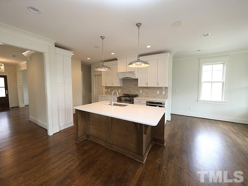 2004 Wiggs Street Raleigh, NC 27608 - Photo 9 of 25 a kitchen with stainless steel appliances a table chairs refrigerator and sink