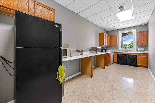 a kitchen with stainless steel appliances granite countertop a refrigerator a sink a stove and a refrigerator