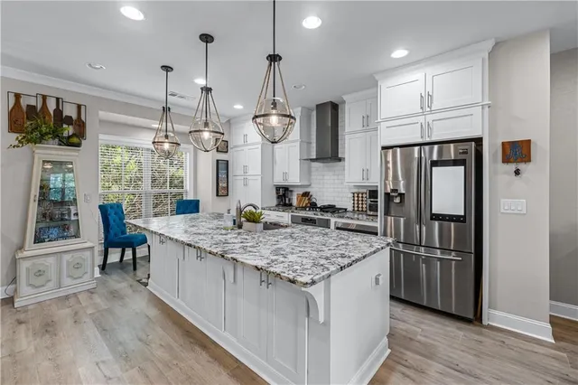 a kitchen with stainless steel appliances granite countertop a refrigerator a sink and a stove