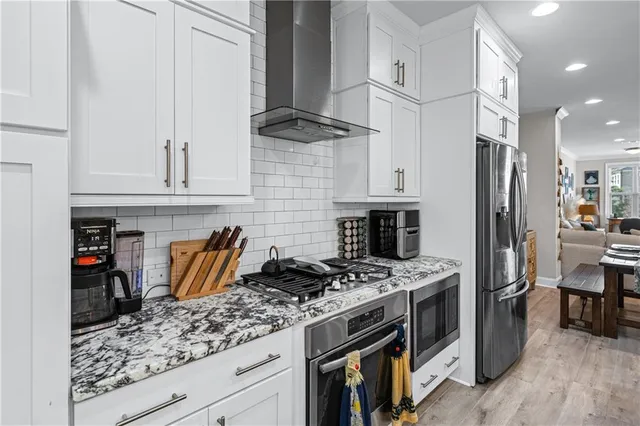 a kitchen with stainless steel appliances granite countertop a stove a refrigerator and a refrigerator