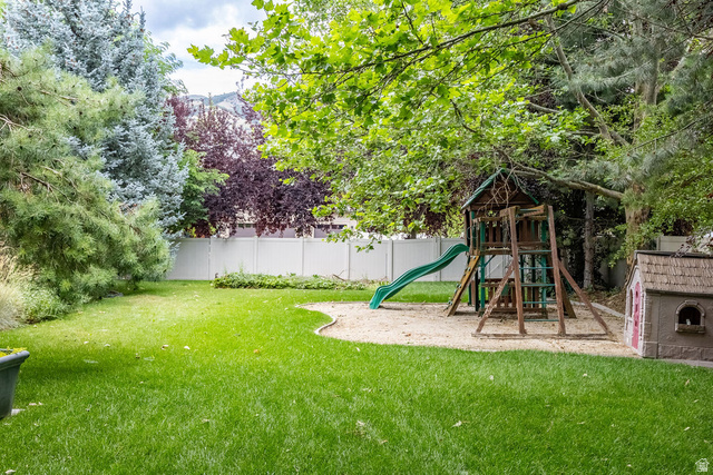 288 525 South Providence, UT 84332 - Photo 63 of 71 Expansive backyard featuring a lush lawn, mature trees, and a white privacy fence