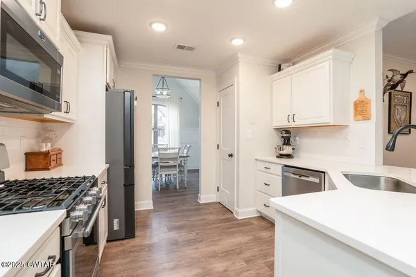 a kitchen with white cabinets and stainless steel appliances