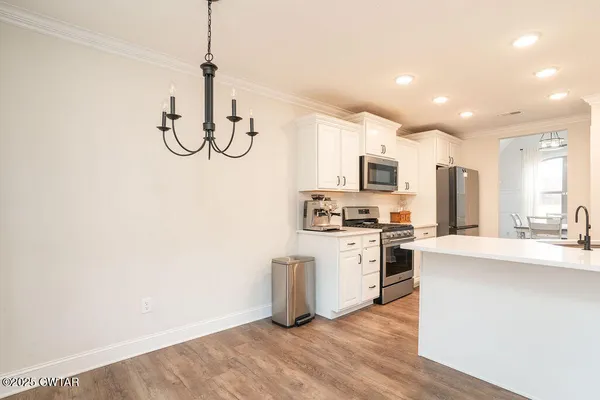 a kitchen with white cabinets and stainless steel appliances
